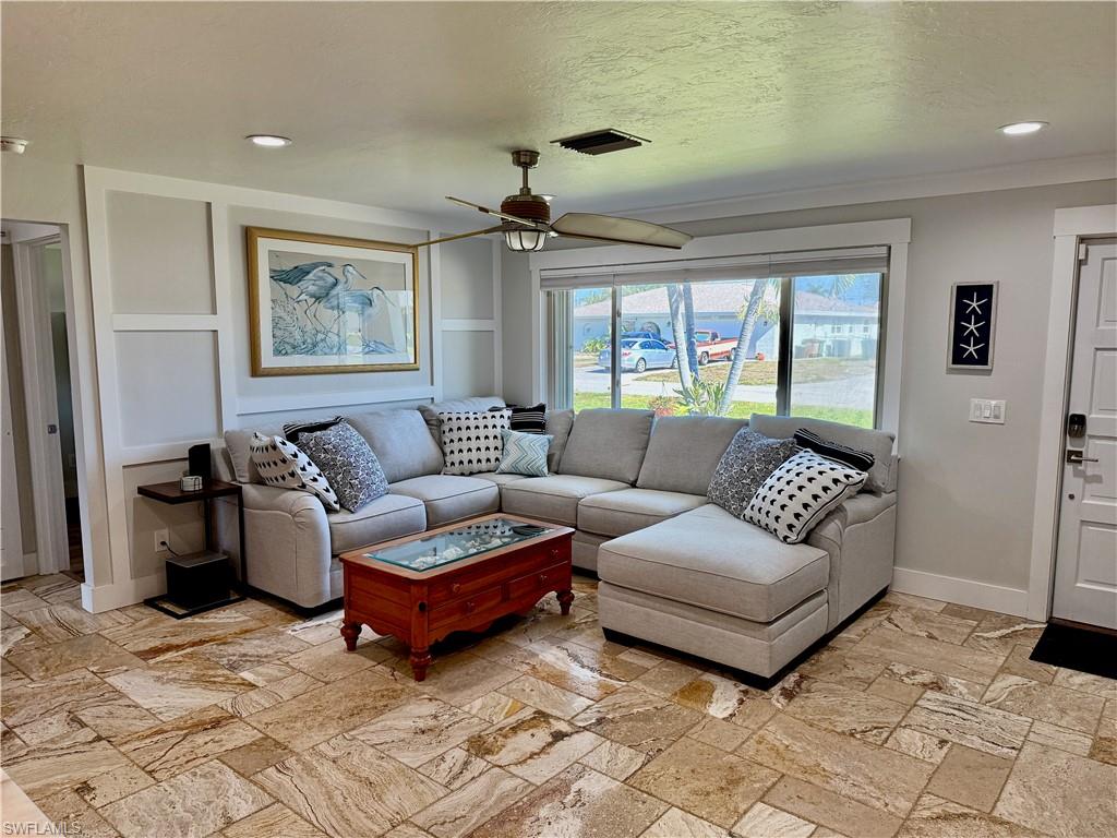 Recessed lighting, crown molding, ceiling fan, board and batten wall detailing, and tile flooring