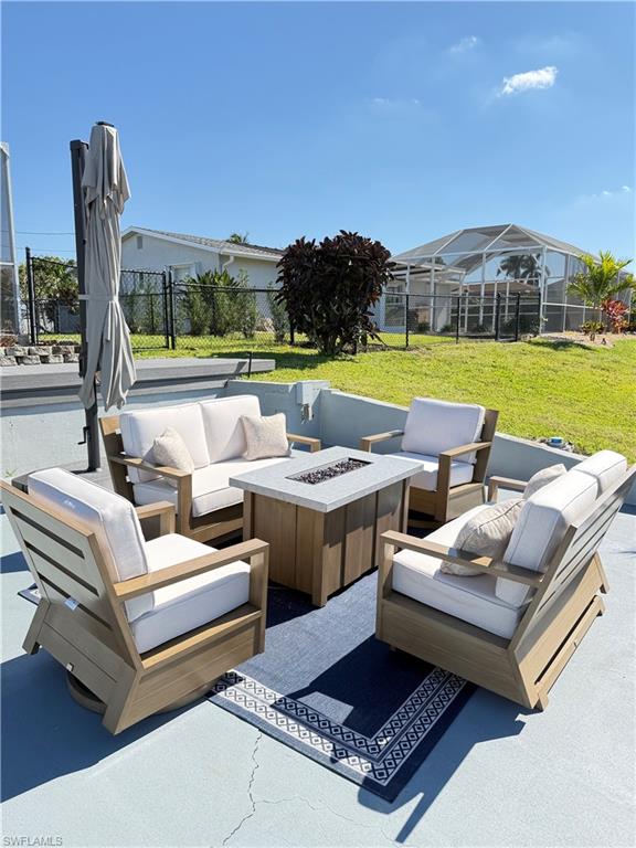 Paved patio area with a built-in fire pit, surrounded by lush green lawn and mature landscaping