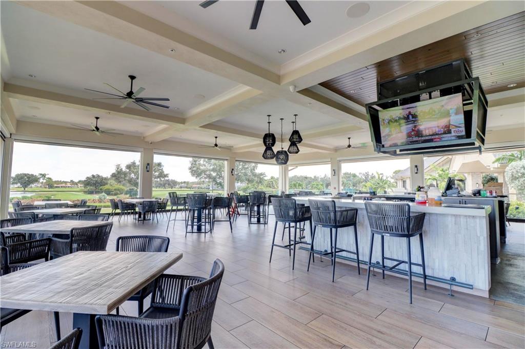 View of patio with exterior bar and ceiling fan