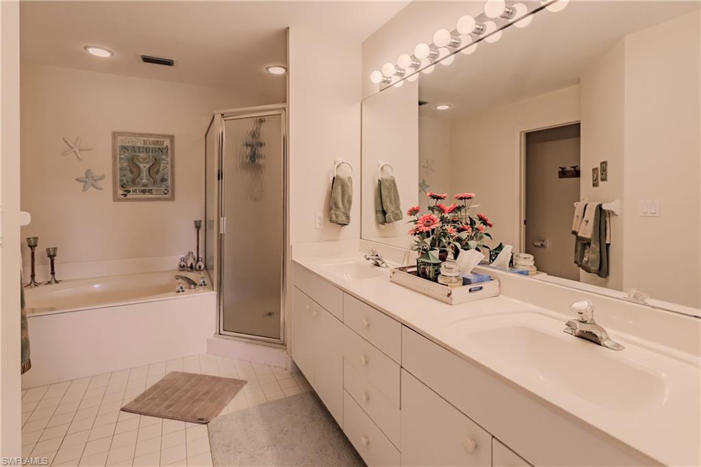 Bathroom featuring vanity, independent shower and bath, and tile patterned floors