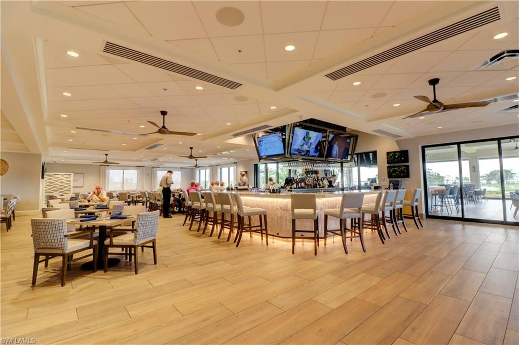 Dining room featuring ceiling fan, bar, and light hardwood / wood-style flooring