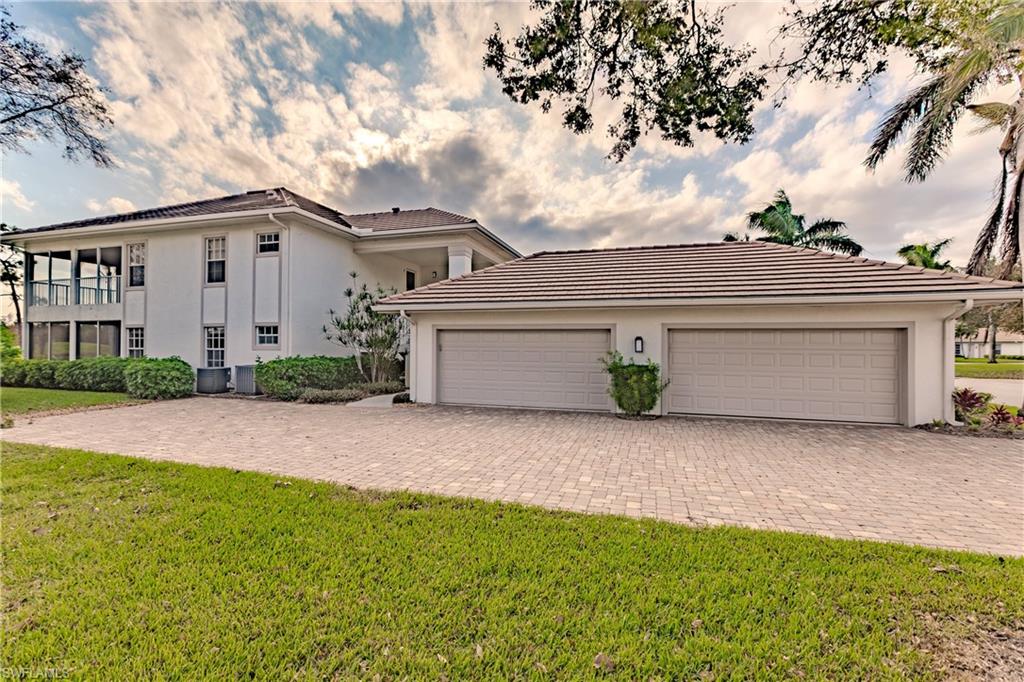 View of front of home featuring a front lawn, a garage, and a balcony
