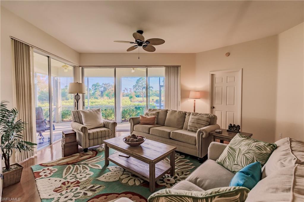 Living room with dark hardwood / wood-style floors and ceiling fan