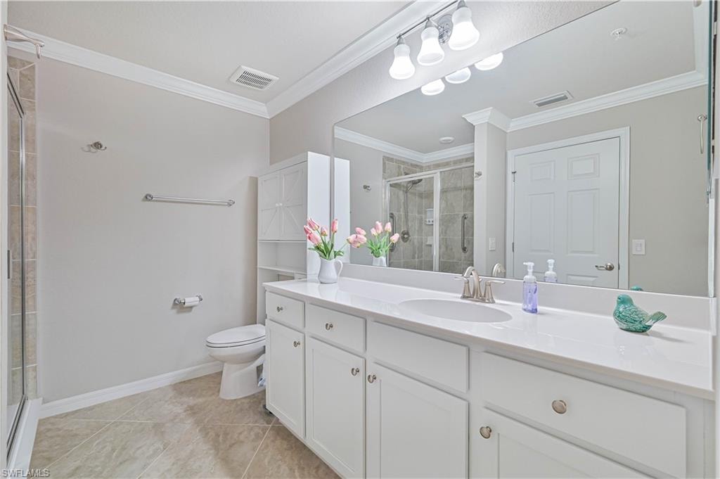 Well-appointed bathroom featuring a spacious vanity with ample storage, solid-surface countertops, and a walk-in glass-enclosed shower with tile surround and large walk in closet for master bedroom
