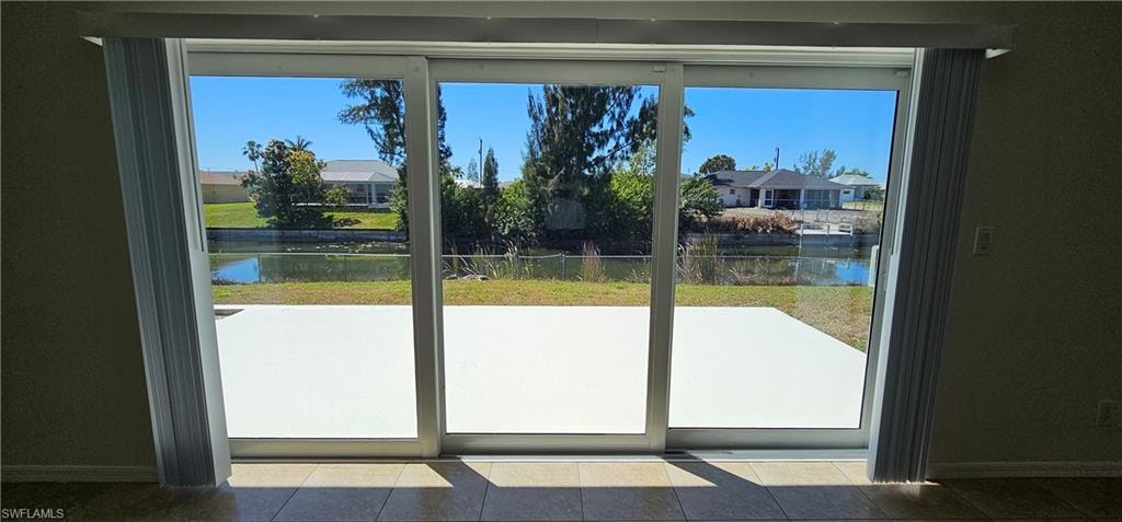 Doorway with a water view and baseboards