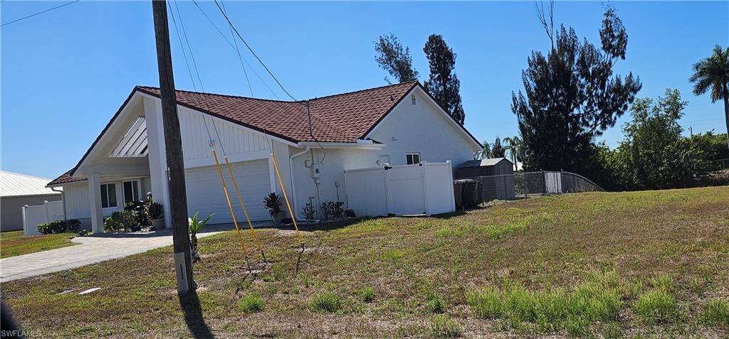 View of property exterior with a garage and driveway