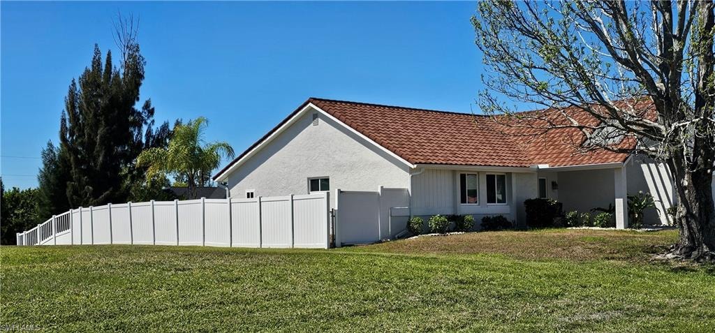 View of property exterior with a tiled roof and stucco siding