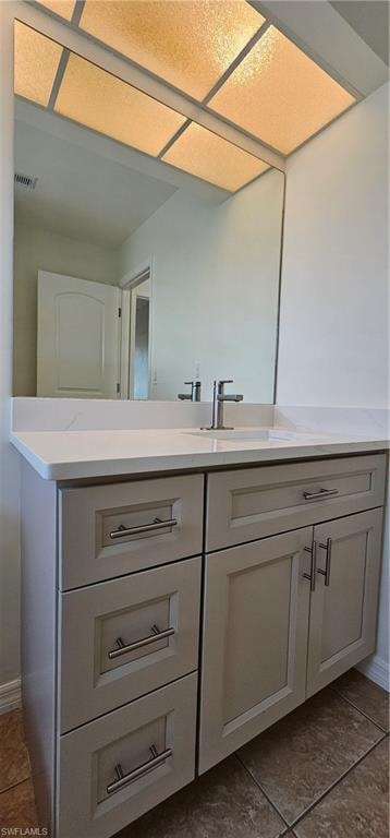 Bathroom with vanity and dark tile patterned floors