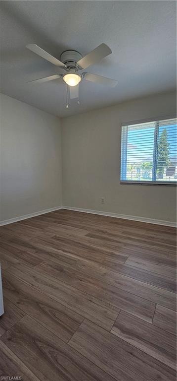 Empty room with dark wood-style flooring and ceiling fan