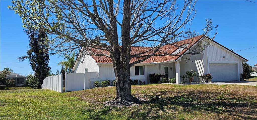 View of front of home with an attached garage, driveway, and a tiled roof
