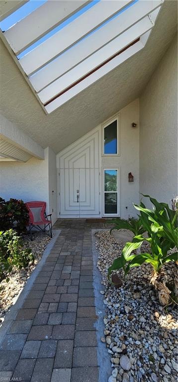 View of exterior entry with stucco siding