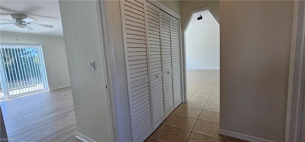 Corridor with baseboards and light tile patterned floors