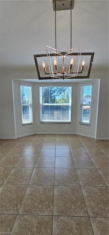 Unfurnished dining area with tile patterned flooring and hanging lights