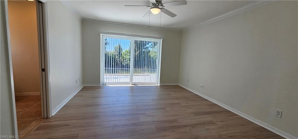 Unfurnished room featuring a ceiling fan, light wood-style flooring, and crown molding