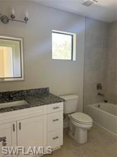 White vanity with a dark speckled countertop, undermount sink, and wall-mounted mirror