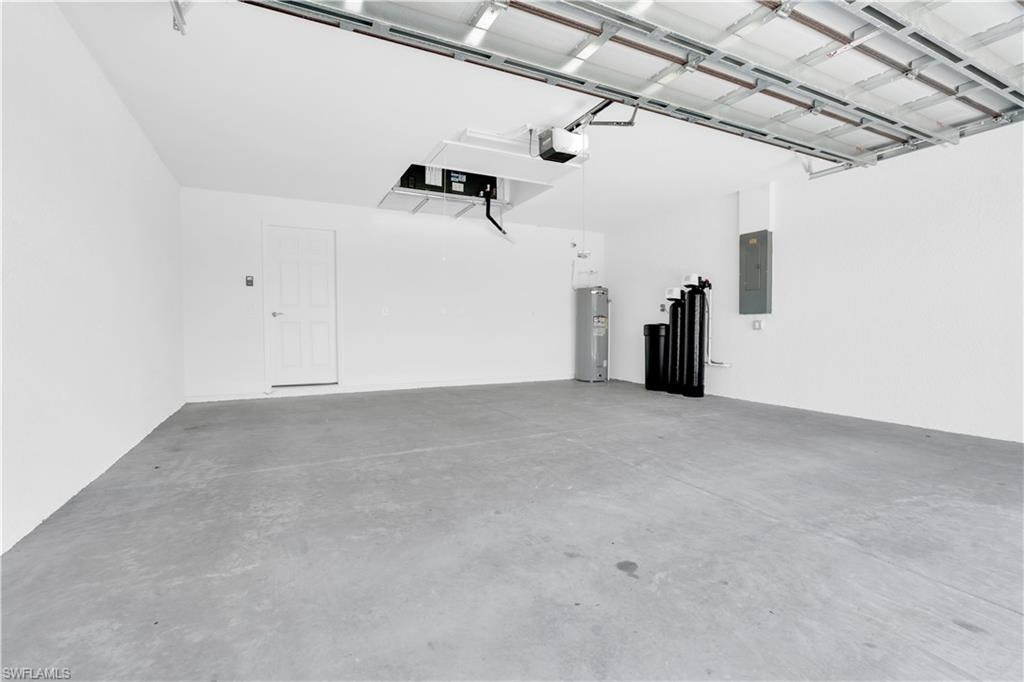Spacious garage featuring a concrete floor, white walls, and an overhead garage door