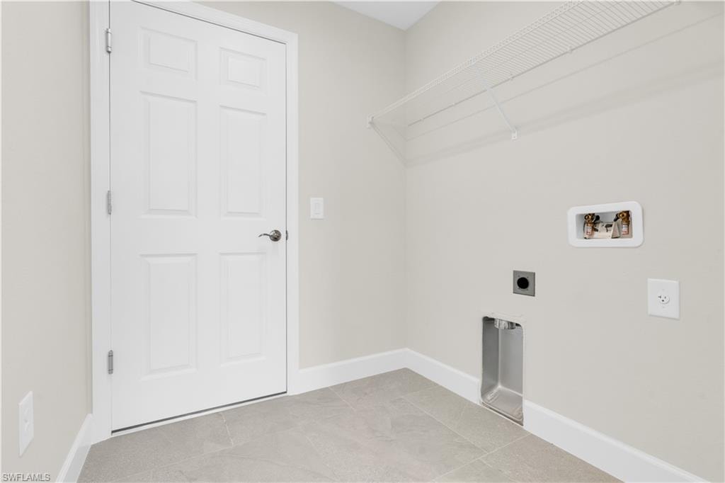 Utility area featuring a six-panel door, wire shelving, and light gray floor tiling