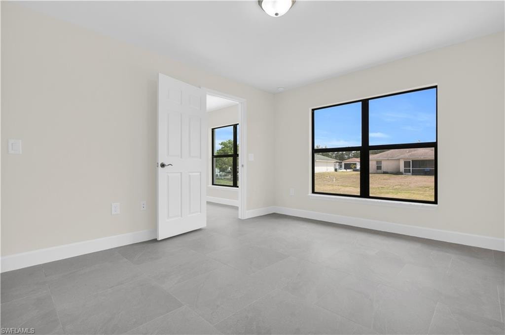 Light gray tile flooring, white baseboards, and neutral wall paint
