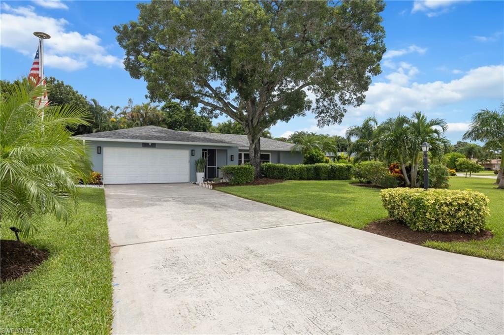 Expansive concrete driveway leading to a two-car garage
