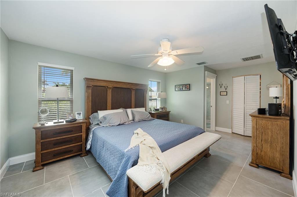 ceiling fan, tile flooring, window with blinds, and white louvered bifold doors
