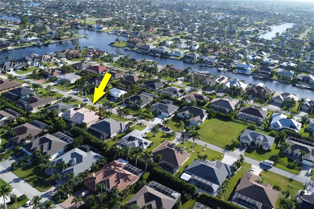 Aerial view of property and surrounding area featuring a nearby body of water and nearby suburban area