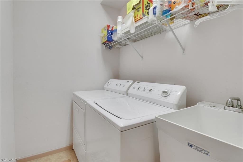 Laundry room featuring washing machine and dryer and baseboards