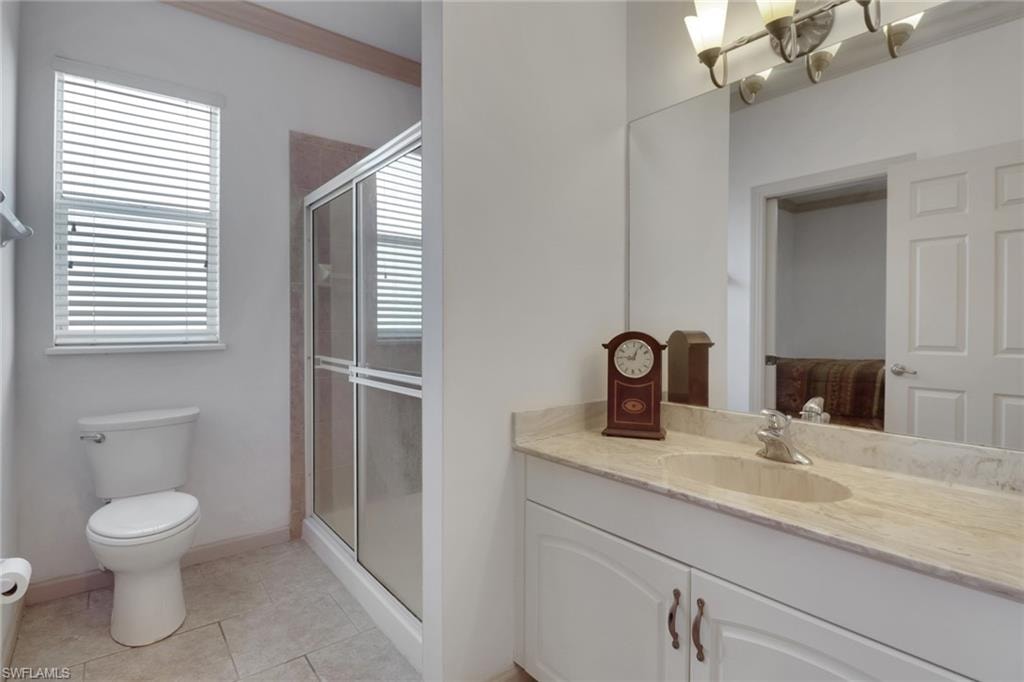 Full bath with vanity, a stall shower, and light tile patterned floors