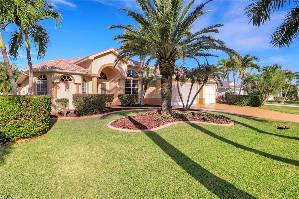 Mediterranean / spanish house with stucco siding, driveway, and a front lawn