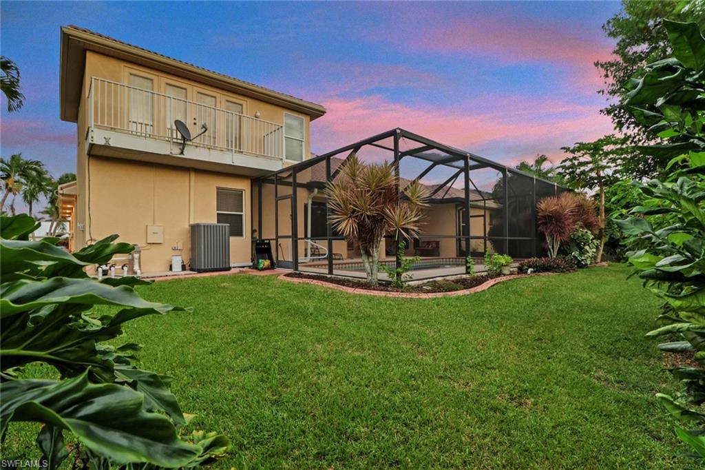Rear view of property featuring a sunroom, glass enclosure, a pool, and stucco siding