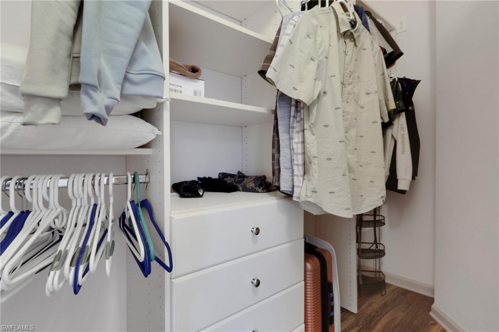 Spacious closet with dark wood-style flooring