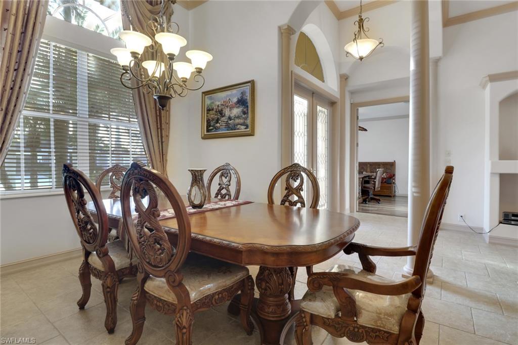 Dining space featuring a chandelier, arched walkways, and light tile patterned floors