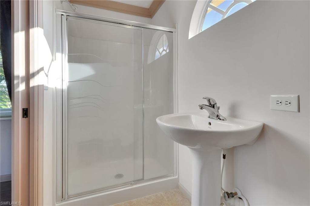 Full bath featuring a shower stall and light tile patterned flooring