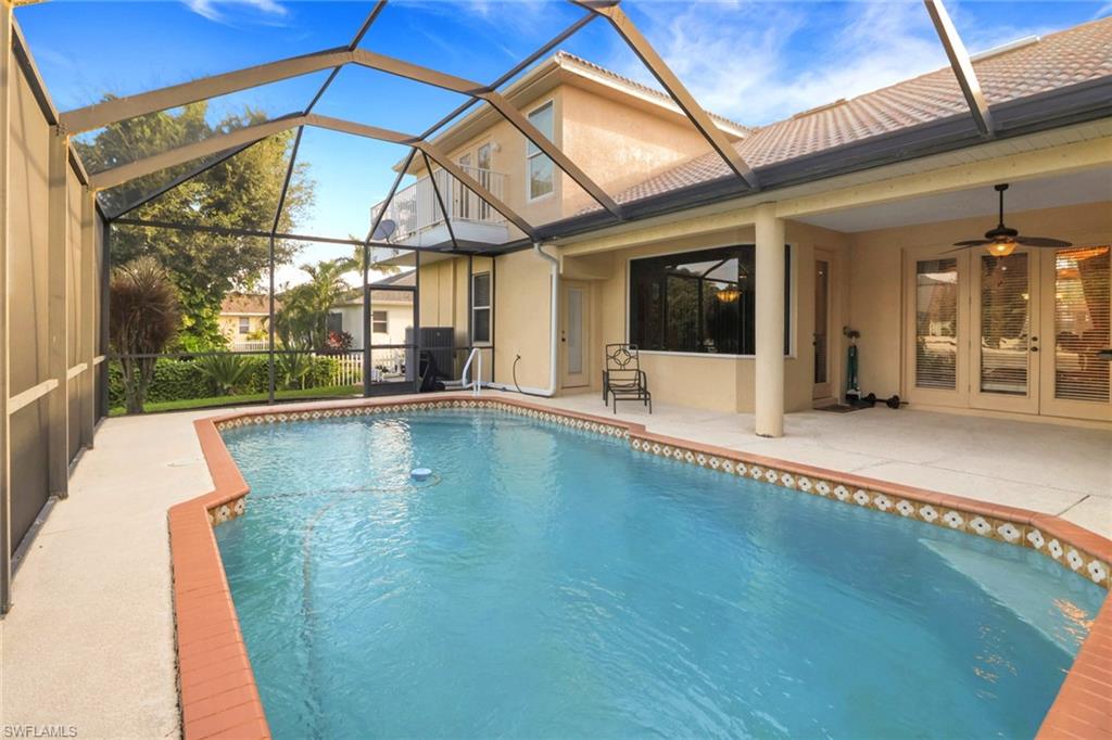 Outdoor pool with a patio area, a sunroom, ceiling fan, and a lanai