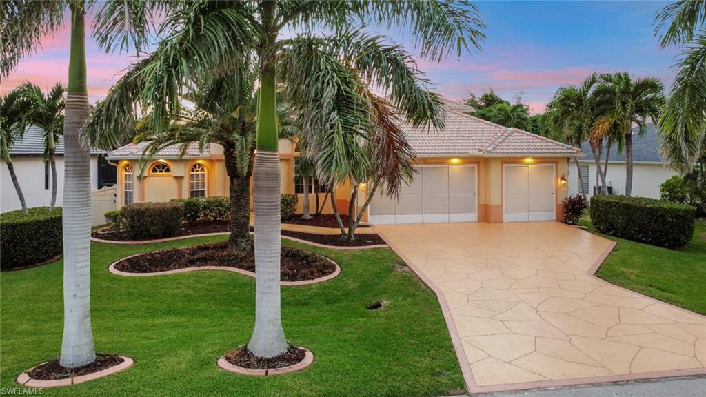 Mediterranean / spanish home featuring stucco siding, a yard, concrete driveway, and a tile roof