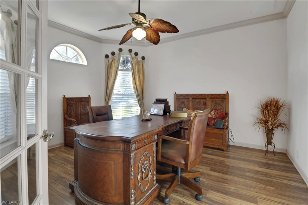 Office space with ornamental molding, ceiling fan, dark wood-style flooring, and french doors