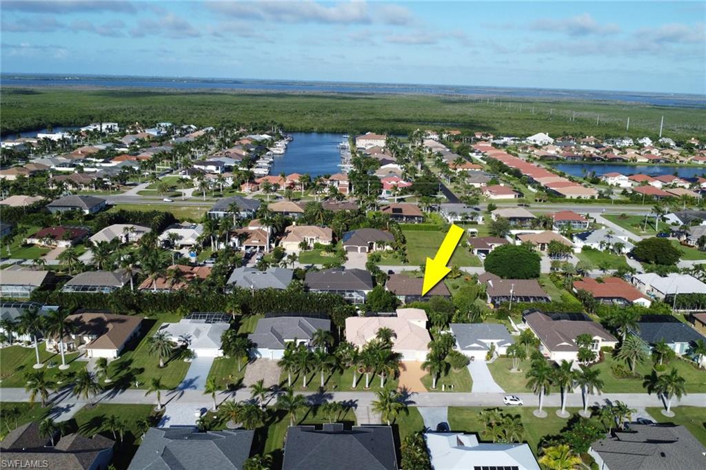Aerial view of property's location featuring a nearby body of water and nearby suburban area