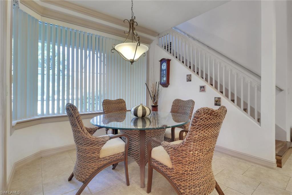 Tiled dining room featuring stairway and baseboards