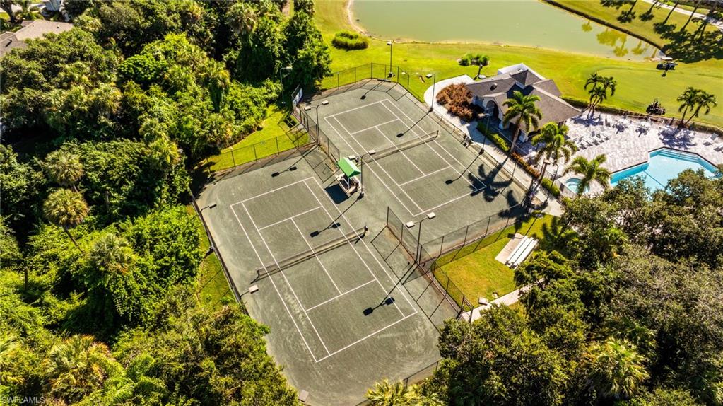 Tennis courts with fencing, permanent lighting, and a shaded seating area