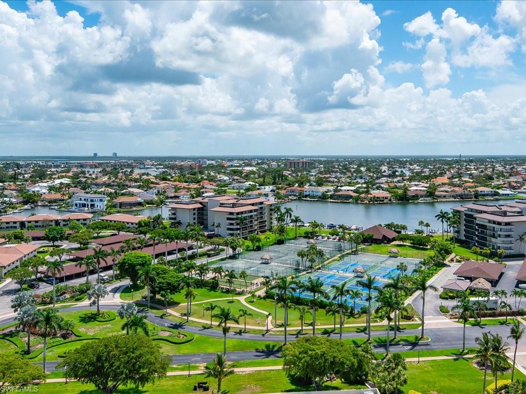 Expansive residential area featuring multiple buildings, lush green spaces, and water features