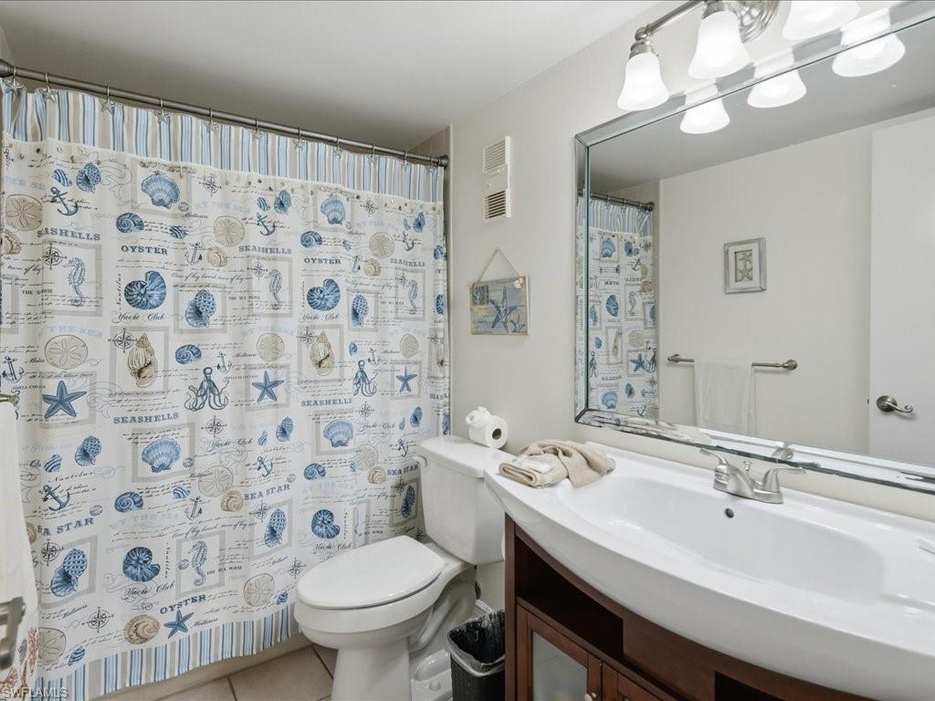 White vanity with an integrated basin, brushed nickel faucet, and wood-finish cabinetry