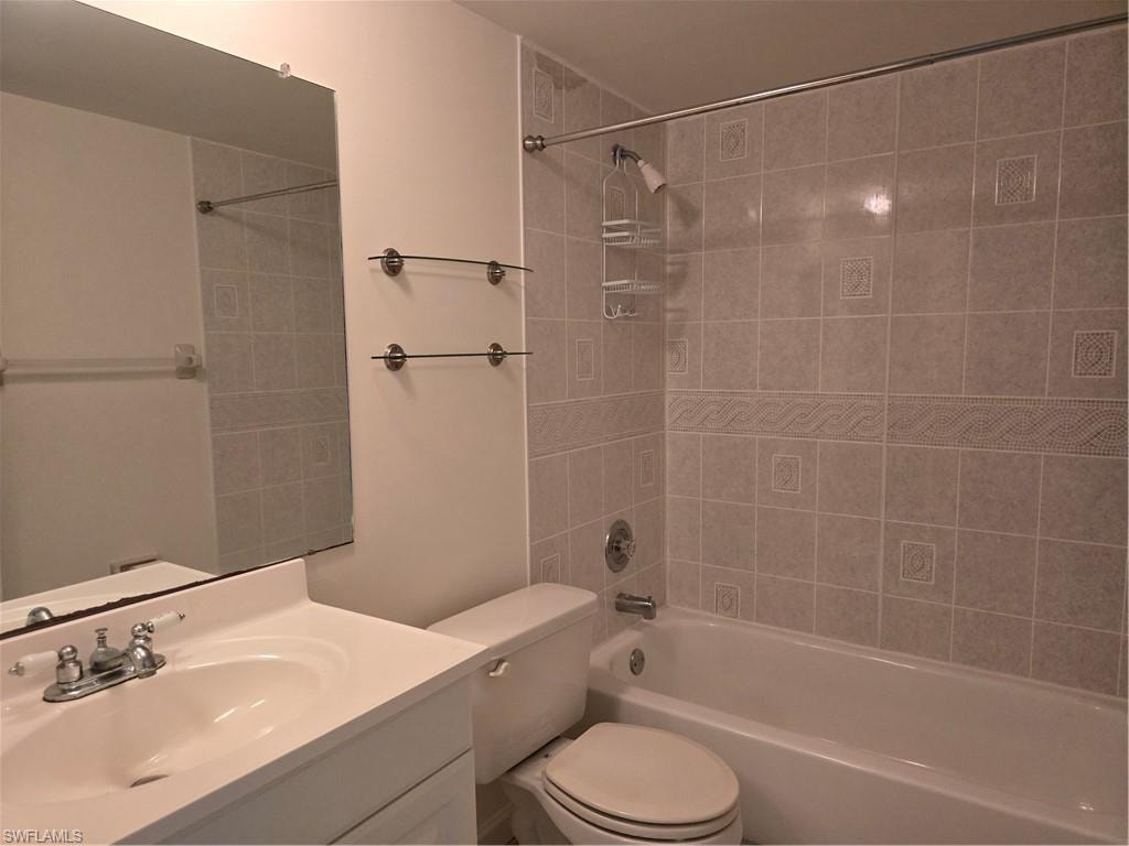 Bathroom vanity with integrated sink, chrome faucet, and expansive wall mirror