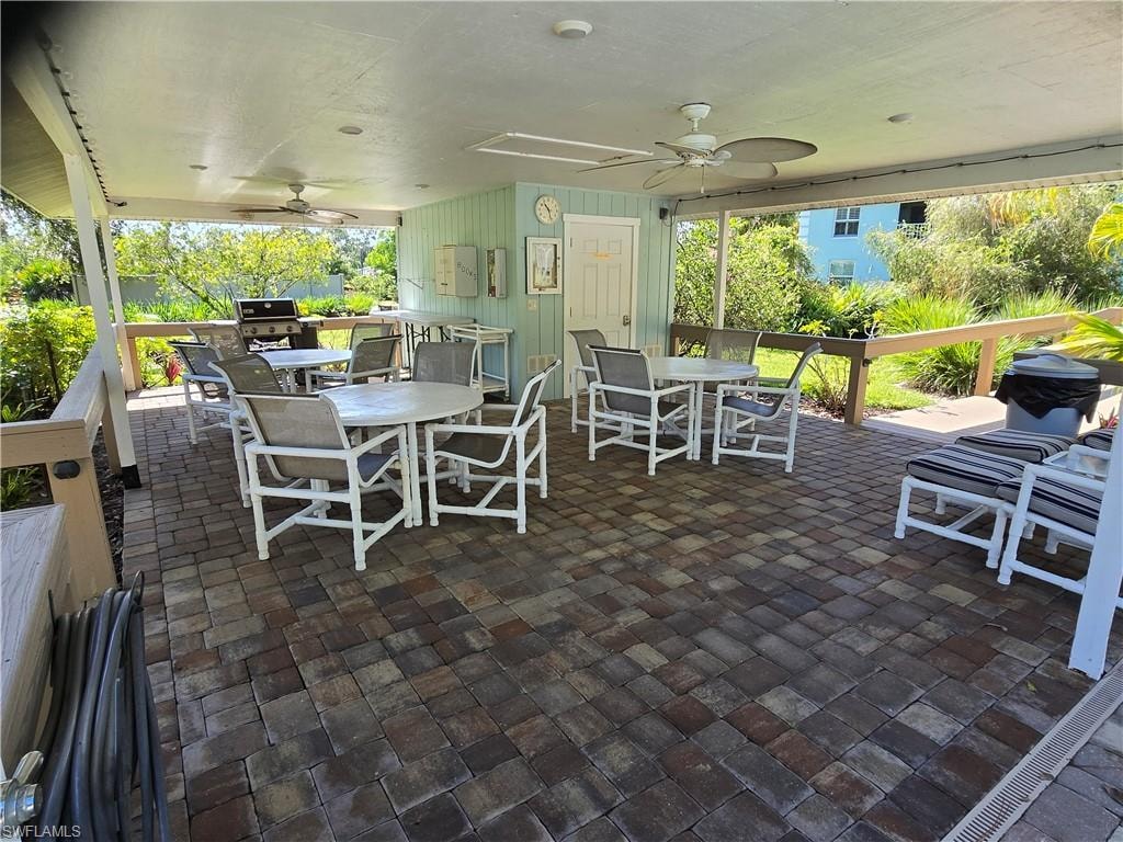 Covered patio with paver flooring, multiple ceiling fans, and BBQ