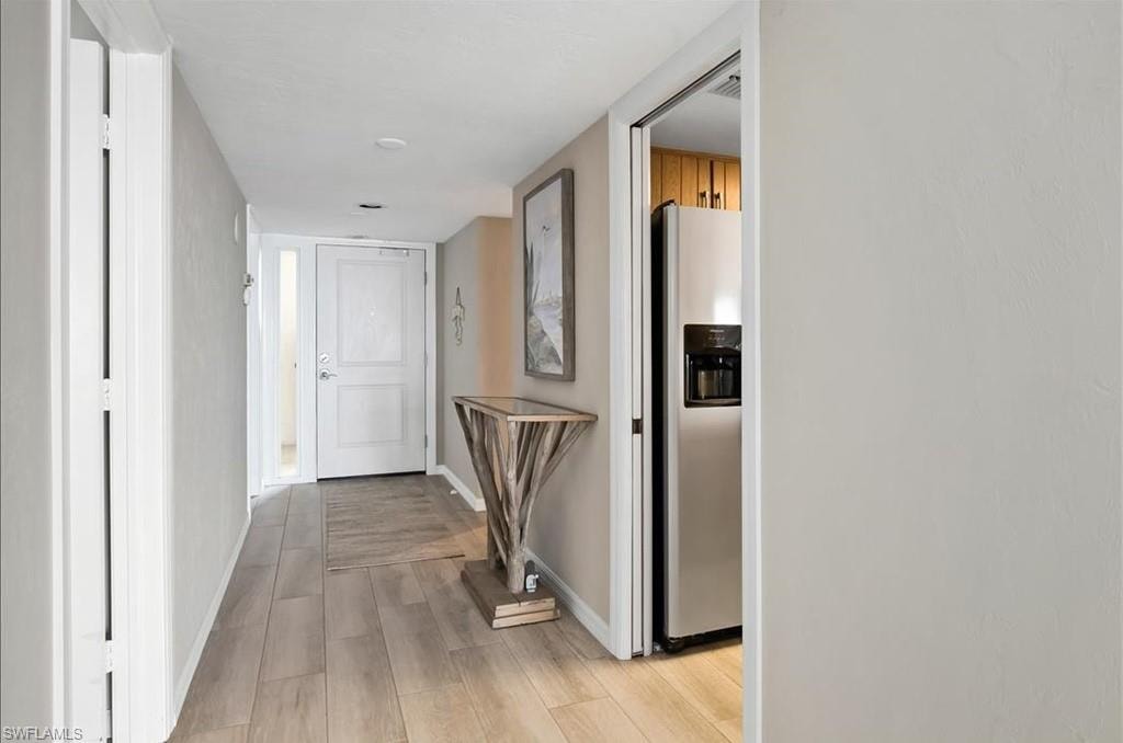 Corridor with light wood finished floors and baseboards