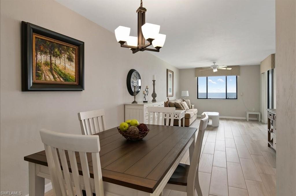 Dining area with a chandelier, light wood finished floors, and ceiling fan