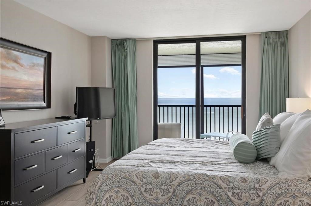Bedroom featuring access to outside and a wall of windows