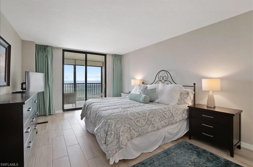 Bedroom with access to outside, floor to ceiling windows, and light wood finished floors