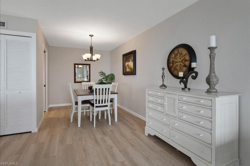 Dining space featuring light wood finished floors and a chandelier