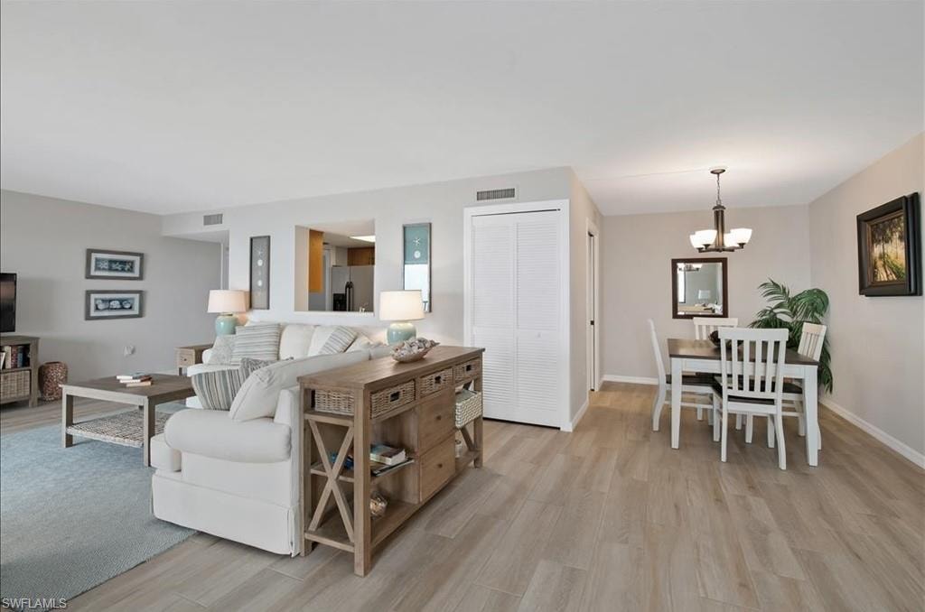 Living room with light wood-style floors and a chandelier