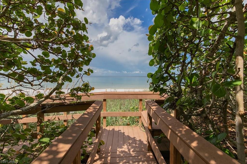 Wooden terrace featuring view of water and beach