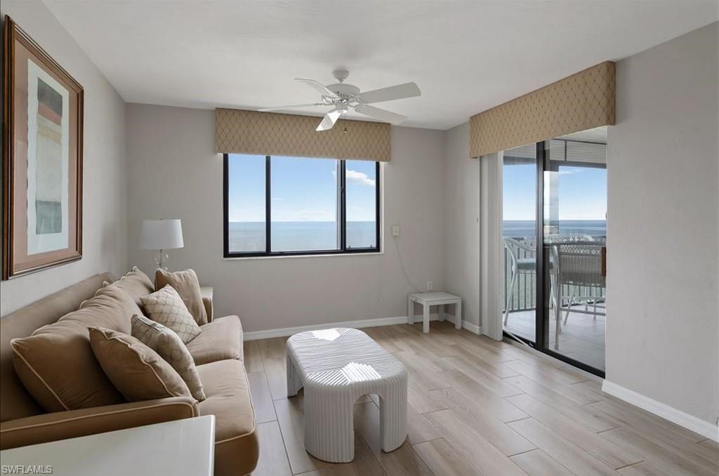 Living room with light wood-type flooring, healthy amount of natural light, and ceiling fan